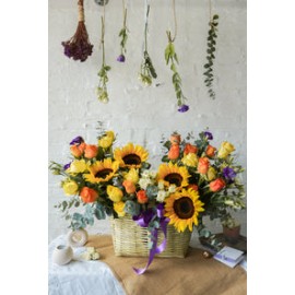 Abril, colorido  arreglo floral en canasta con girasoles