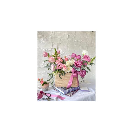 Tania, cesta con exquisita variedad de flores rosadas.