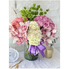 Clara, arreglo floral con 2 buckets de rosas y rodeado de orquídeas .