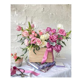 Tania, cesta con exquisita variedad de flores rosadas.