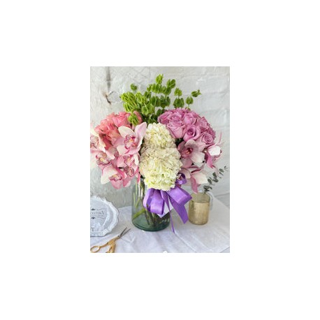 Clara, arreglo floral con 2 buckets de rosas y rodeado de orquídeas .